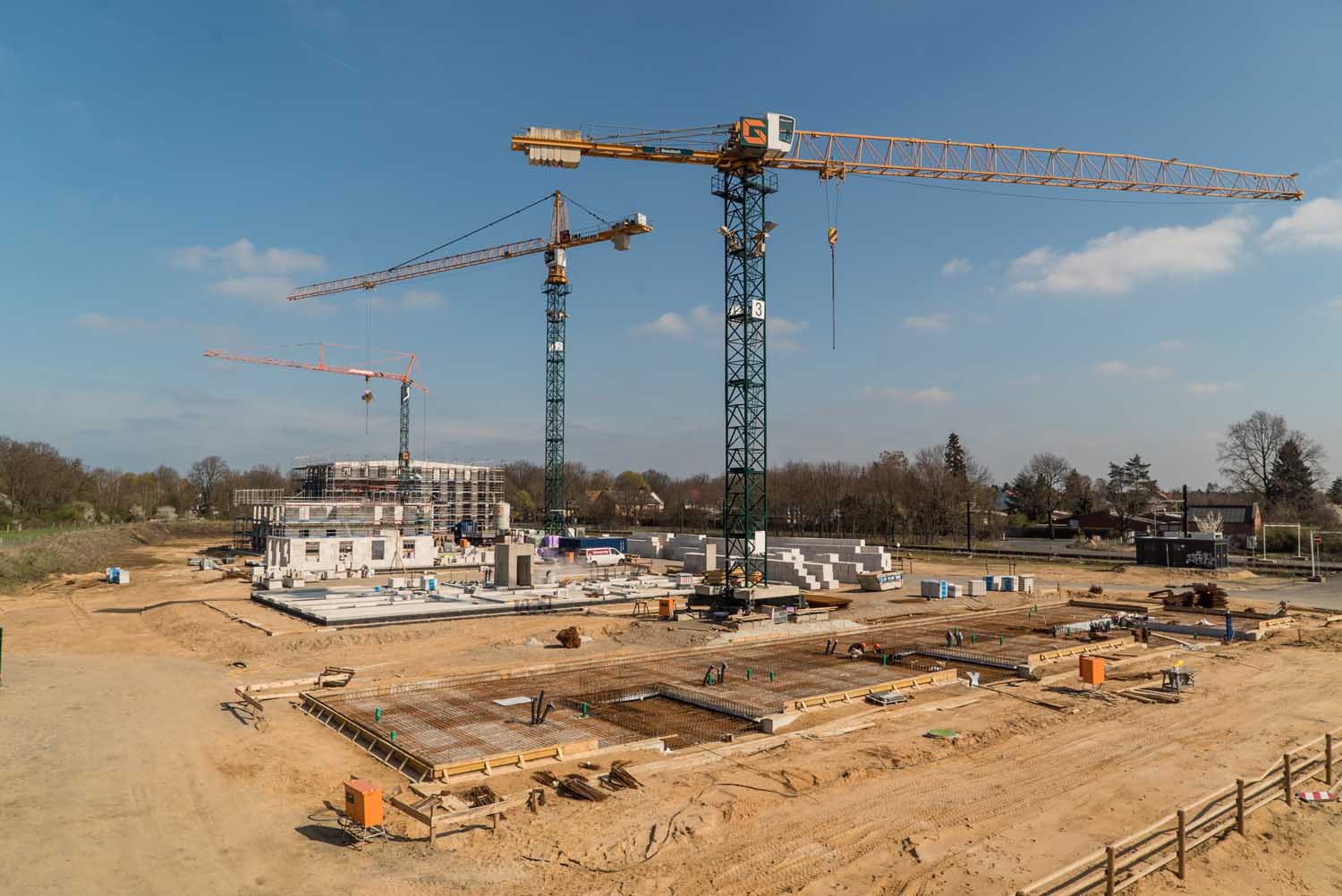Baufeld mit Fundamenten und mehreren Baukränen