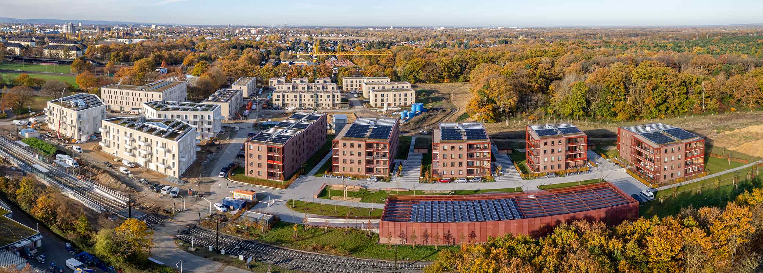 Panorama aus der Luft im Herbst 2021: erste fertige Häuser am Waldrand