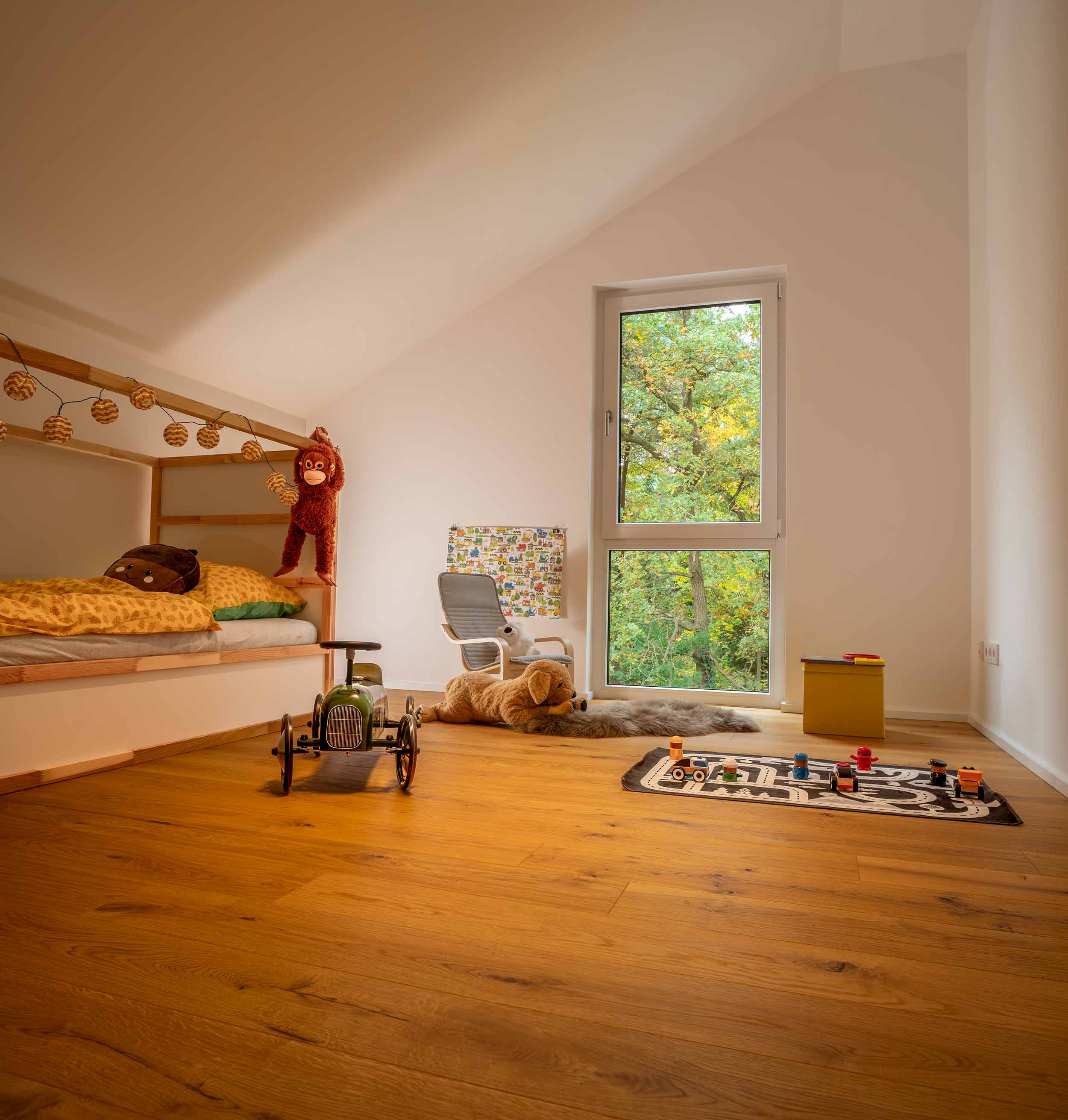 Kinderzimmer unter der Dachschräge mit Holzboden und Spielsachen